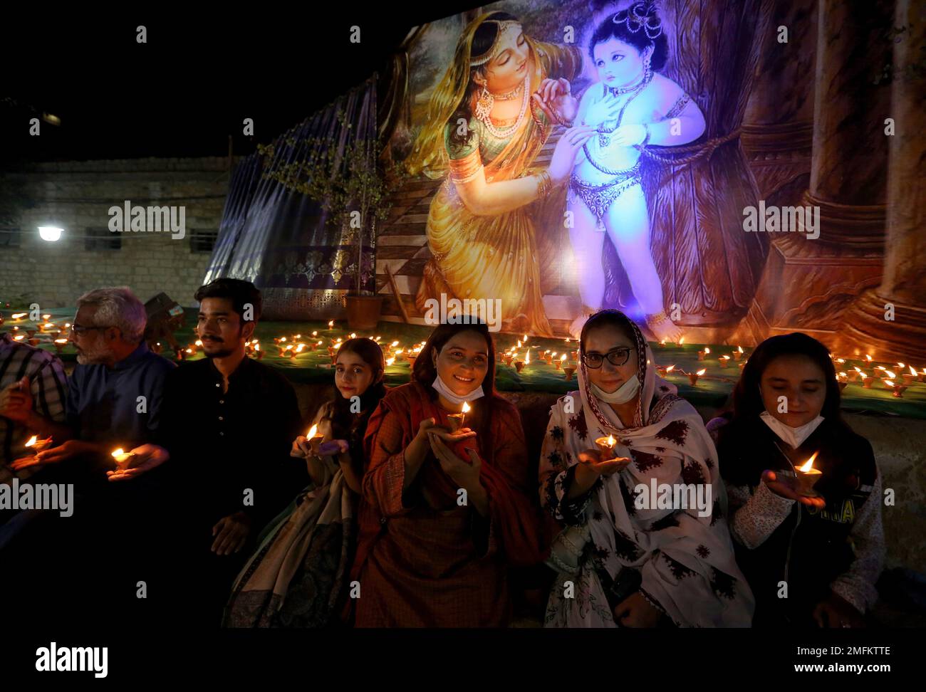A Hindu family hold claylamps during a ceremony to celebrate Diwali