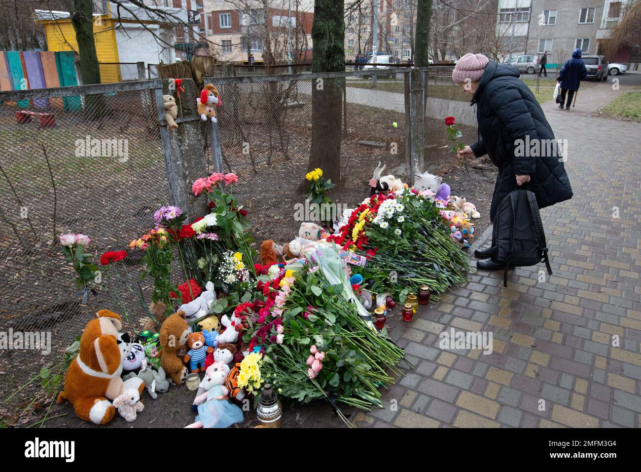 A woman brings flowers in memory of the victims at the site of a ...