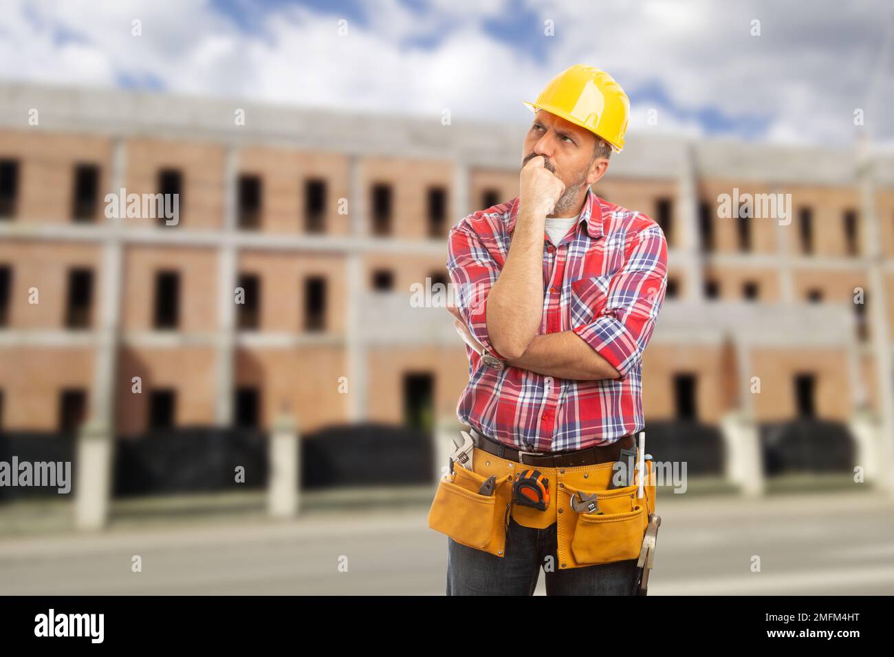 Worker making thinking gesture with hands on chin as looking for solution concept Stock Photo
