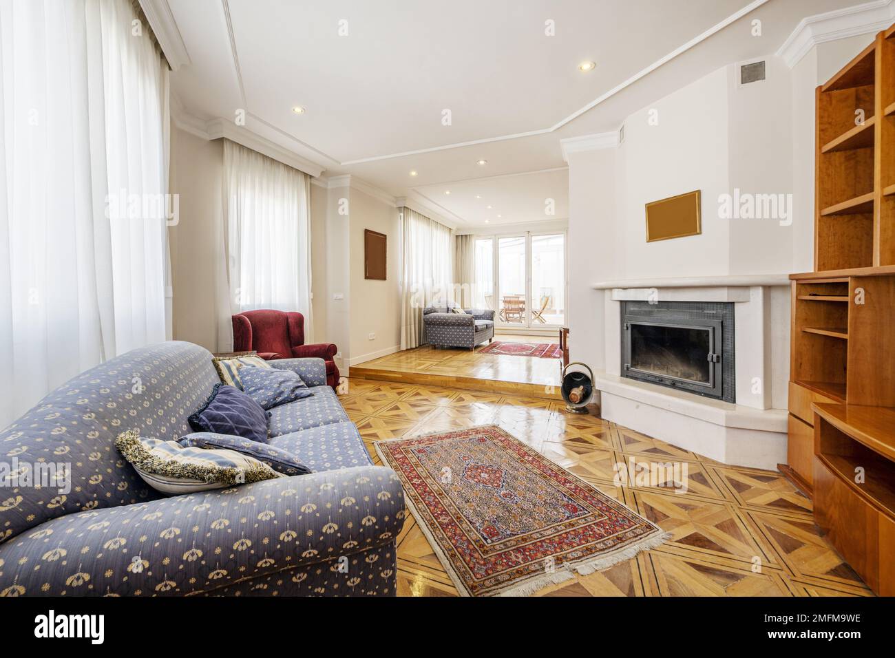 Long living room with two heights, several upholstered sofas and a