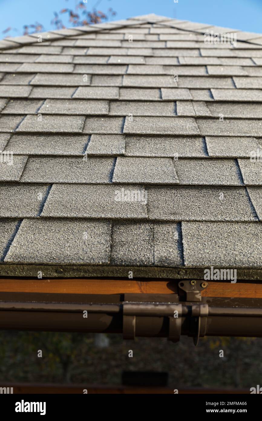 Frosted roof covered with bitumen shingles. The beginning of winter