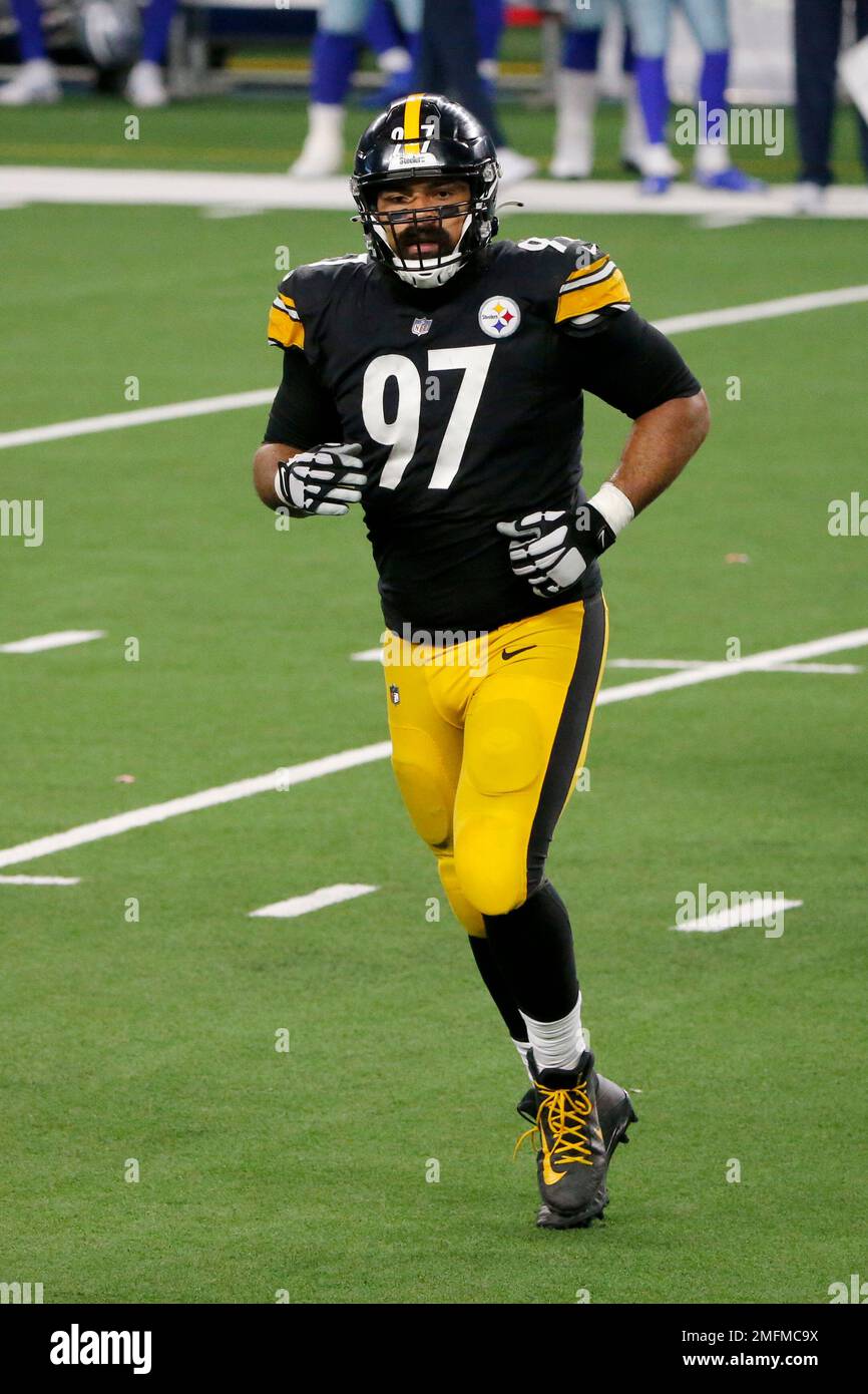 Pittsburgh Steelers defensive tackle Cameron Heyward (97) carries a flag  with Franco Harris number 32 on to the field before the start of the game  against the Las Vegas Raiders at Acrisure