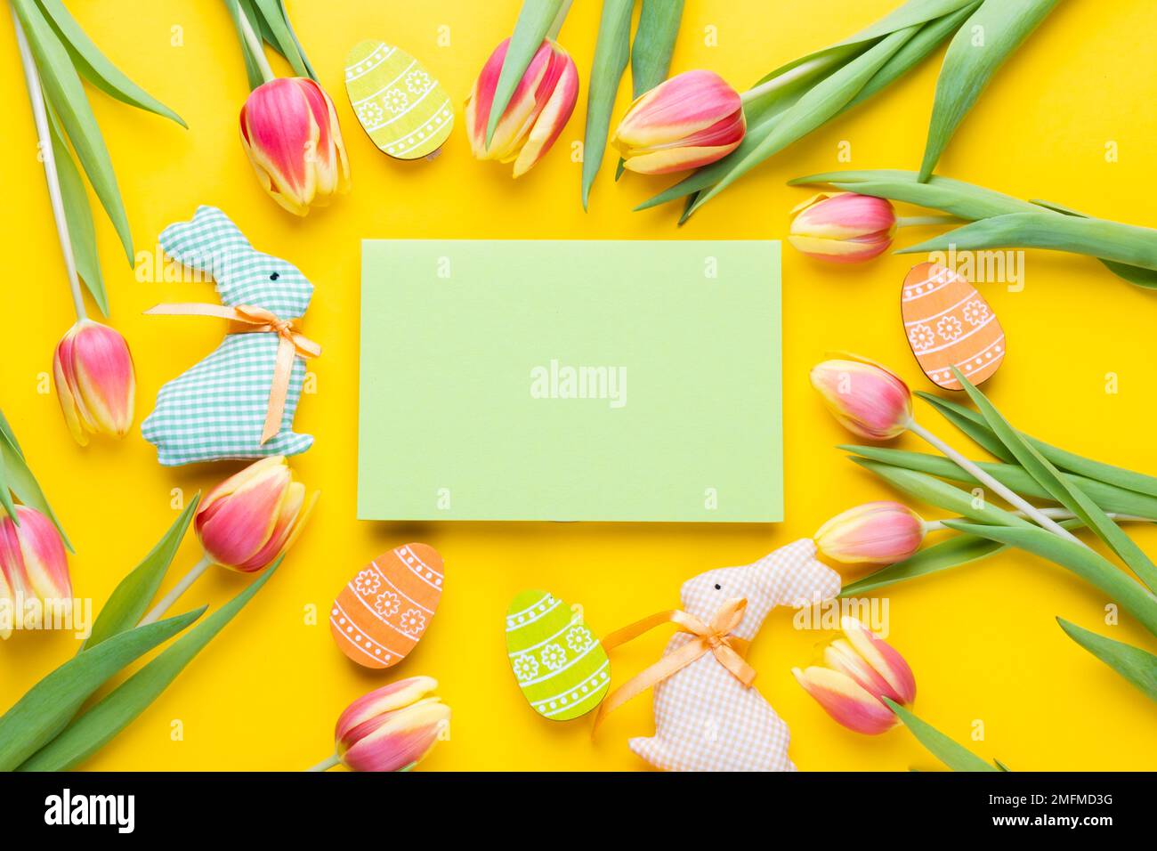 Template for Easter greeting card. Easter festive frame with eggs, tulips and easter bunny Stock Photo