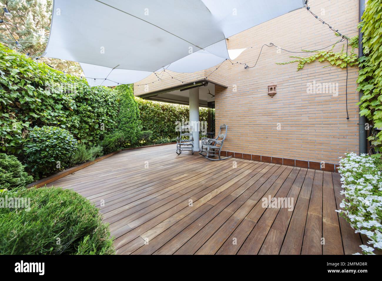 Terrace of a ground floor house with hedges and ornamental plants