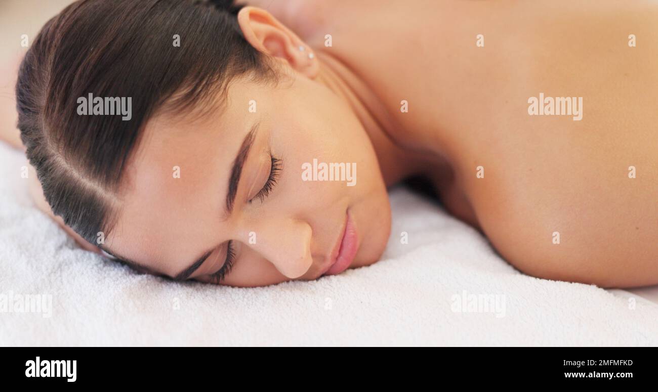 Spa, wellness and woman, calm and happy, peaceful after massage, massage therapy for body health and zen. Young person satisfied, lying down and Stock Photo