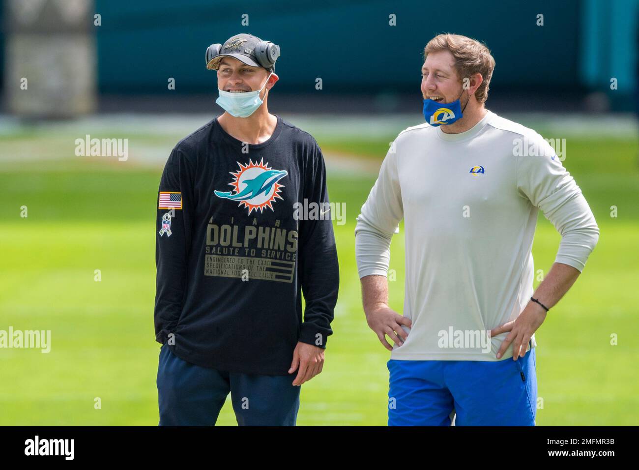 From left, Miami Dolphins wide receivers coach Josh Grizzard and Los  Angeles Rams assistant quarterbacks coach Liam Coen smile as they wear  masks on the field before an NFL football game, Sunday,