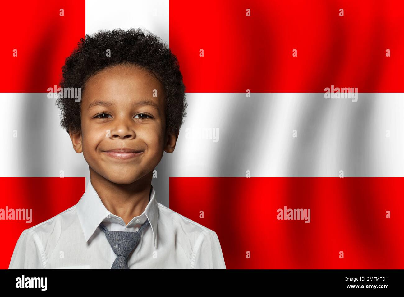 Danish kid boy on flag of Denmark background. Education and childhood concept Stock Photo