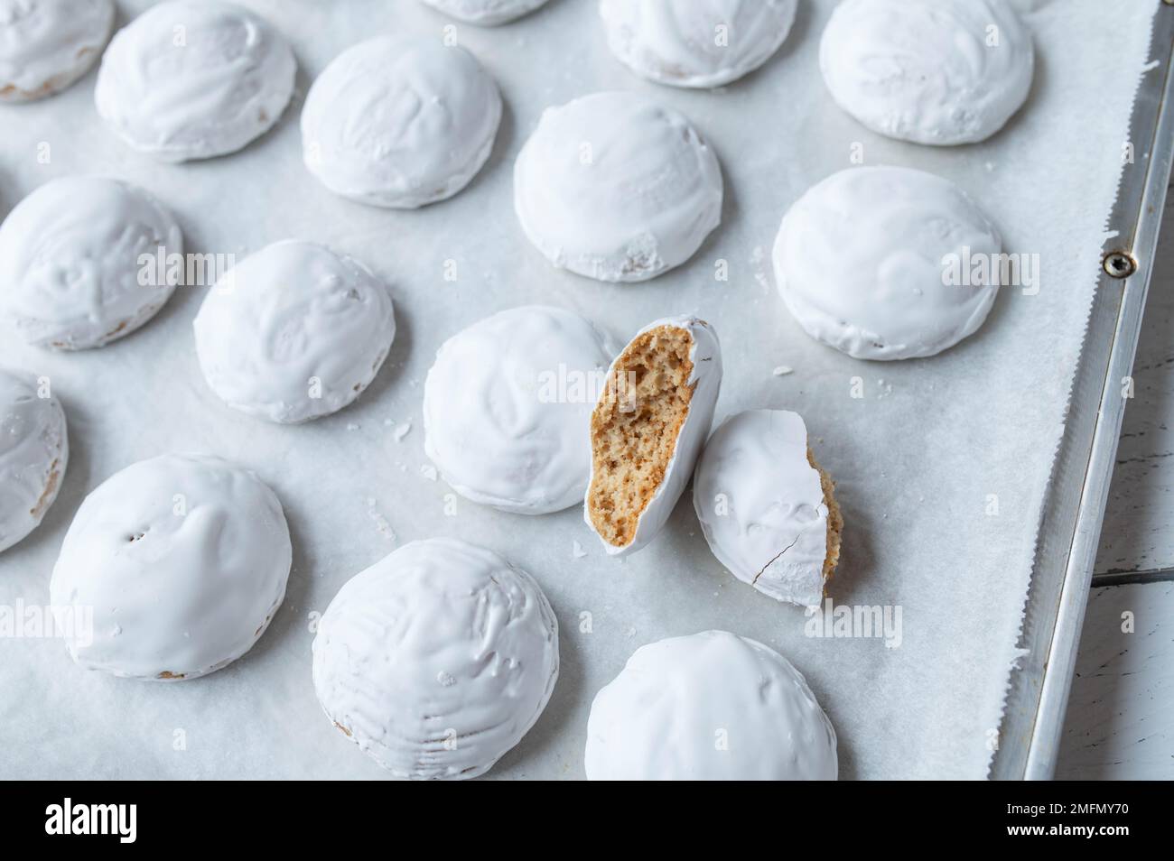 Fresh baked gingerbread cookies with egg white icing on a baking sheet Stock Photo