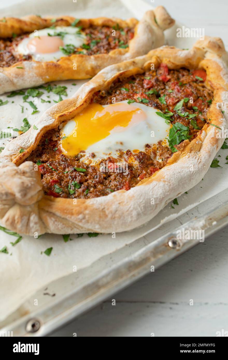 Turkish pide with ground beef, vegetable filling and egg Stock Photo