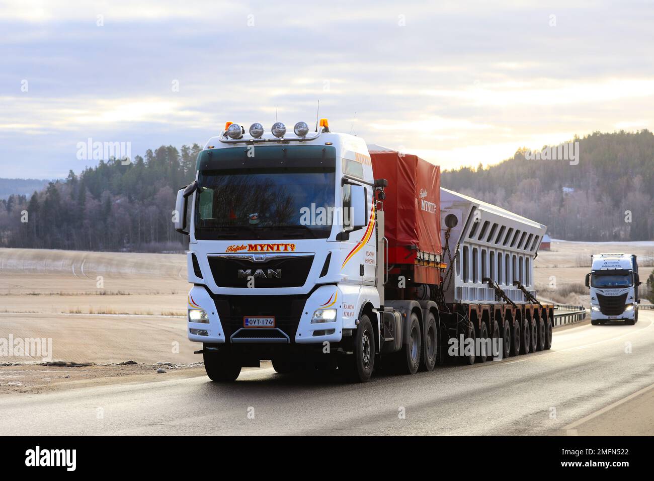 MAN TGX 33.580 truck transports industrial object as oversize load on multi-axle trailer on highway 52. Salo, Finland. January 20, 2023. Stock Photo