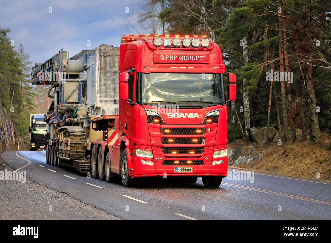 Red Scania R770 truck of PHP Group Oy hauls crushing and screening equipment as oversize load along highway. Salo, Finland. January 20, 2022. Stock Photo