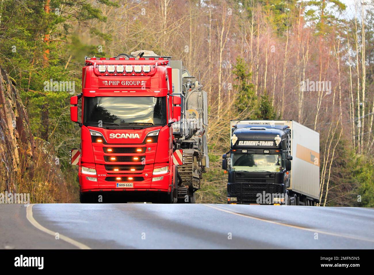 Red Scania R770 truck of PHP Group Oy hauls crushing and screening equipment as oversize load in traffic. Salo, Finland. January 20, 2022. Stock Photo