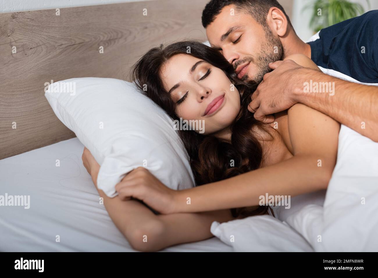 Young man touching brunette girlfriend on bed in morning,stock image Stock Photo picture image