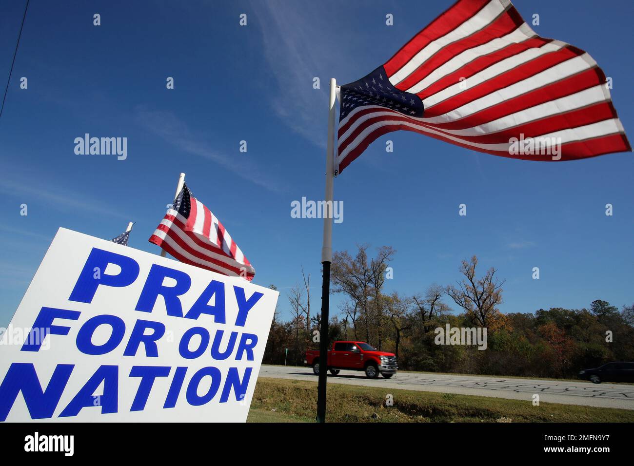 American flags fly over a sign reading 'Pray For Our Nation' on Friday