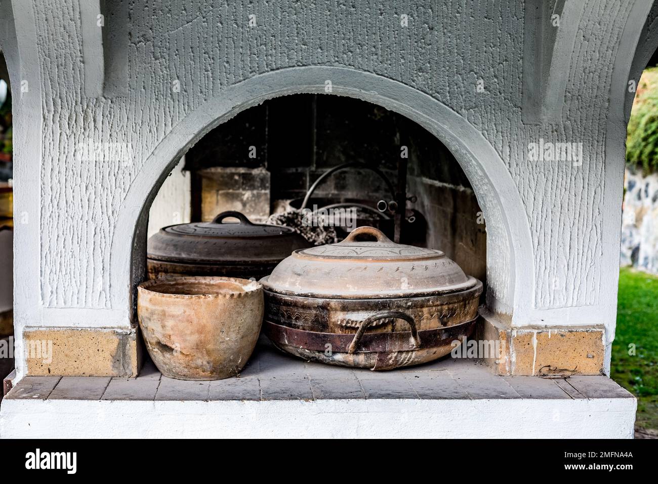 Used dirty earthen pots lay inside Balkan style brick barbeque, Serbia