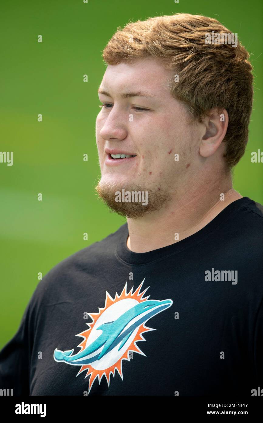 Miami Dolphins guard Michael Deiter (63) carries a football as he warms up  on the field before an NFL football game against the Buffalo Bills, Sunday,  Sept. 19, 2021, in Miami Gardens