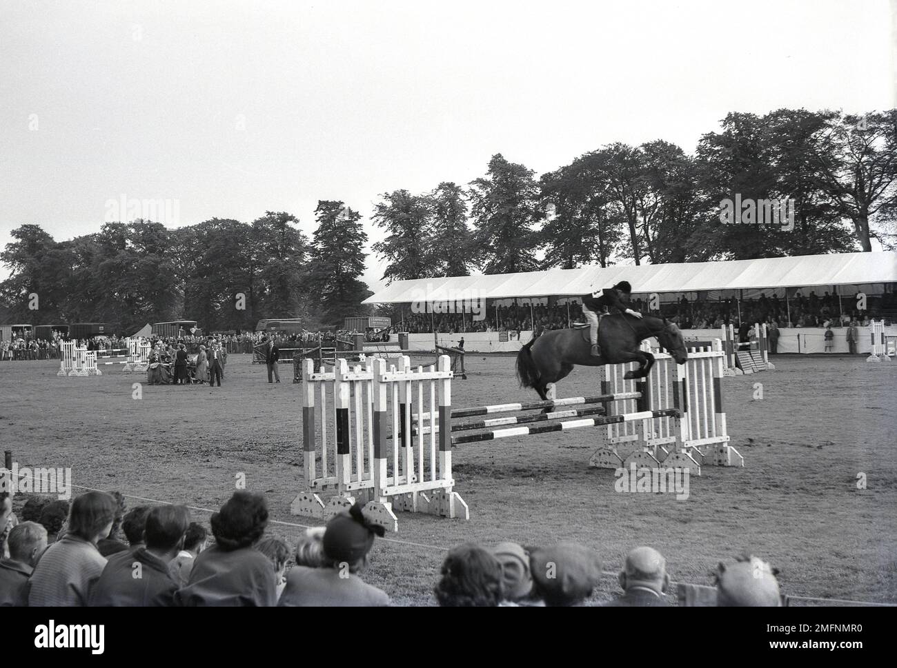 1960s, historical, show jumping, watched by spectators, a boy riding a horse, jumping an obstacle or fence at a Horse Show, held at the Didsbury Agricultural Society Exhibition Grounds, Manchester, England, UK. Primarily for junior riders, it started as in 1963 as a local event, the Didsbury Light Horse Show and still takes place in Didsbury today, Stock Photo
