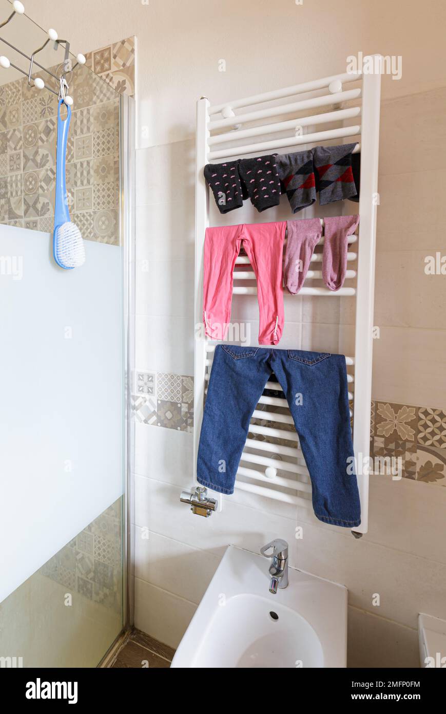 A visually striking composition of laundry, suspended above an elegantly designed bathroom radiator, illustrates an innovative utilization of space Stock Photo