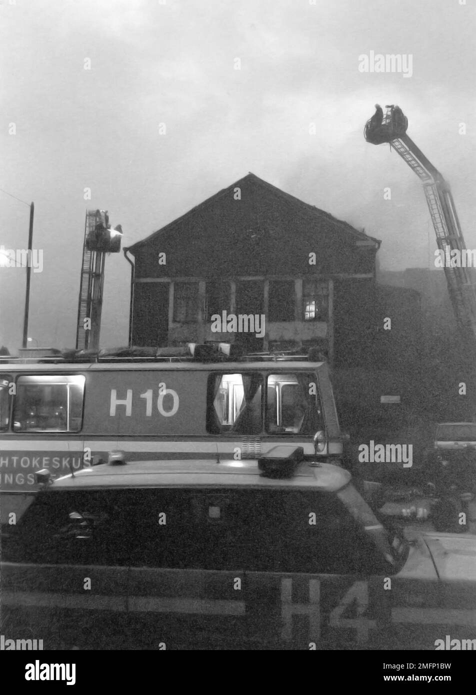 Helsinki fire department command vehicle (H4) and mobile command post vehicle (H10) at a fire in Sörnäinen, circa 1996. In the background, the fire is being fought from aerial work platforms. Stock Photo