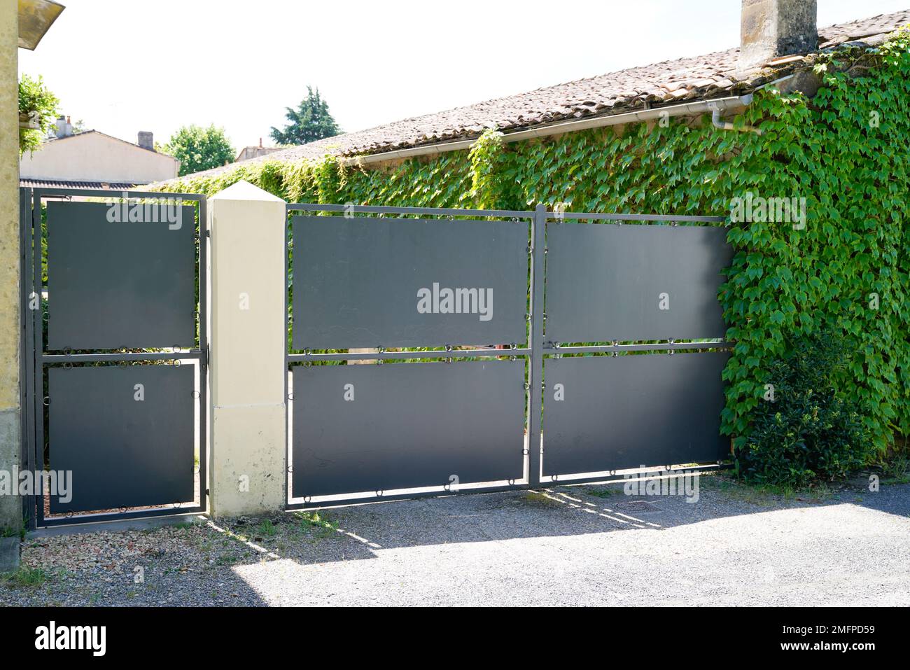 steel dark gray paint metal gate house portal of suburb home door Stock