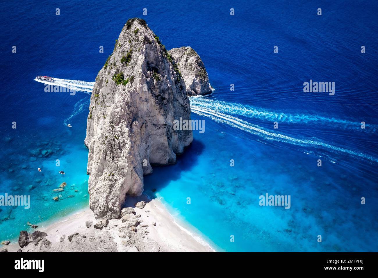 A large tour boat passing by the Myzithres beach, a secluded headland, one of the most scenic spots on the island of Zakynthos, Greece Stock Photo