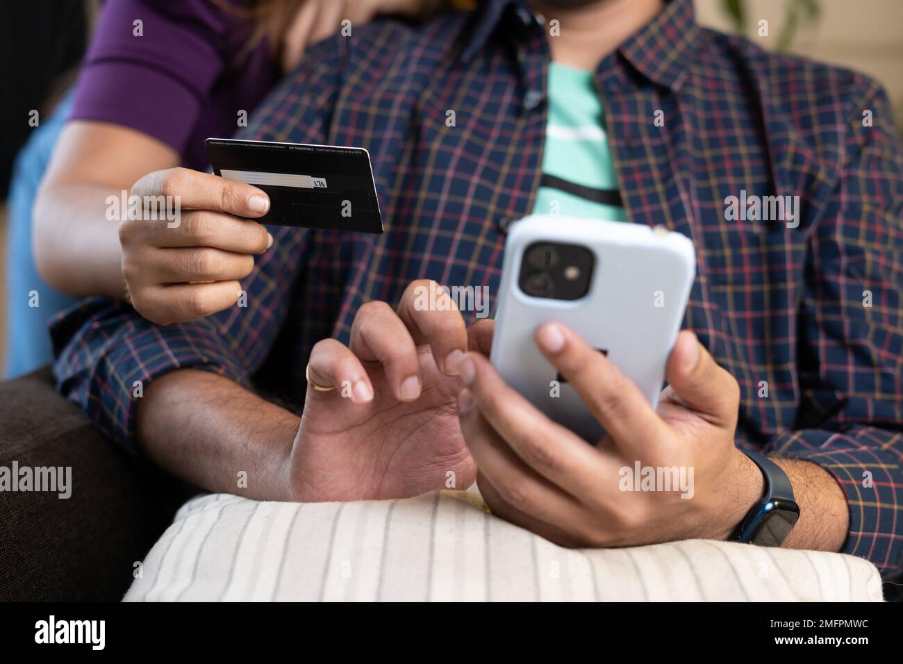 Close up shot of couple hands making online purchase or ecommerce shooping on smartphone by using credit card at home - conept of bill payment Stock Photo