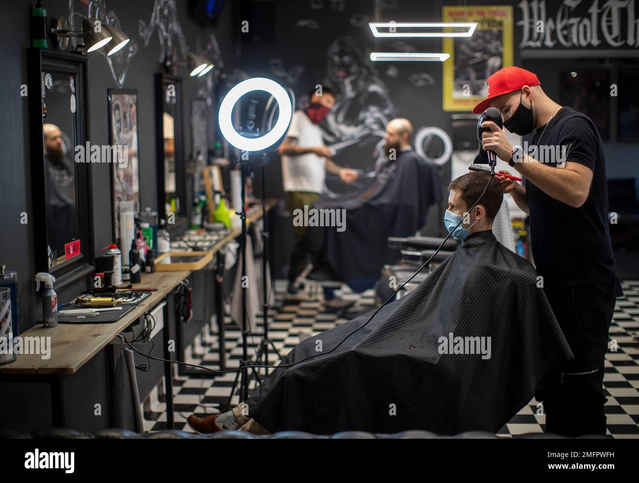 Customers gets their hair cut by barbers at barbershop Red Light