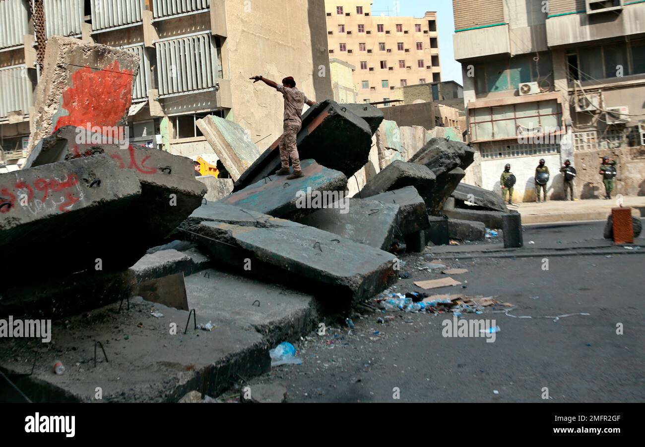 Iraqi security forces remove concrete blocks to open roads near the ...