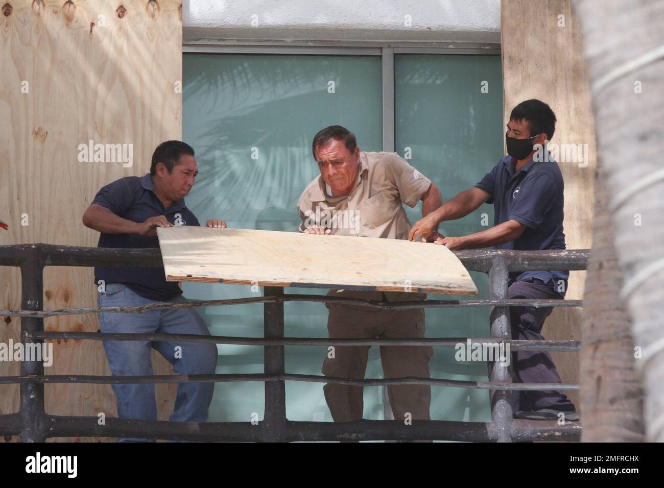 Beach hotel workers cover doors and windows with plywood as they