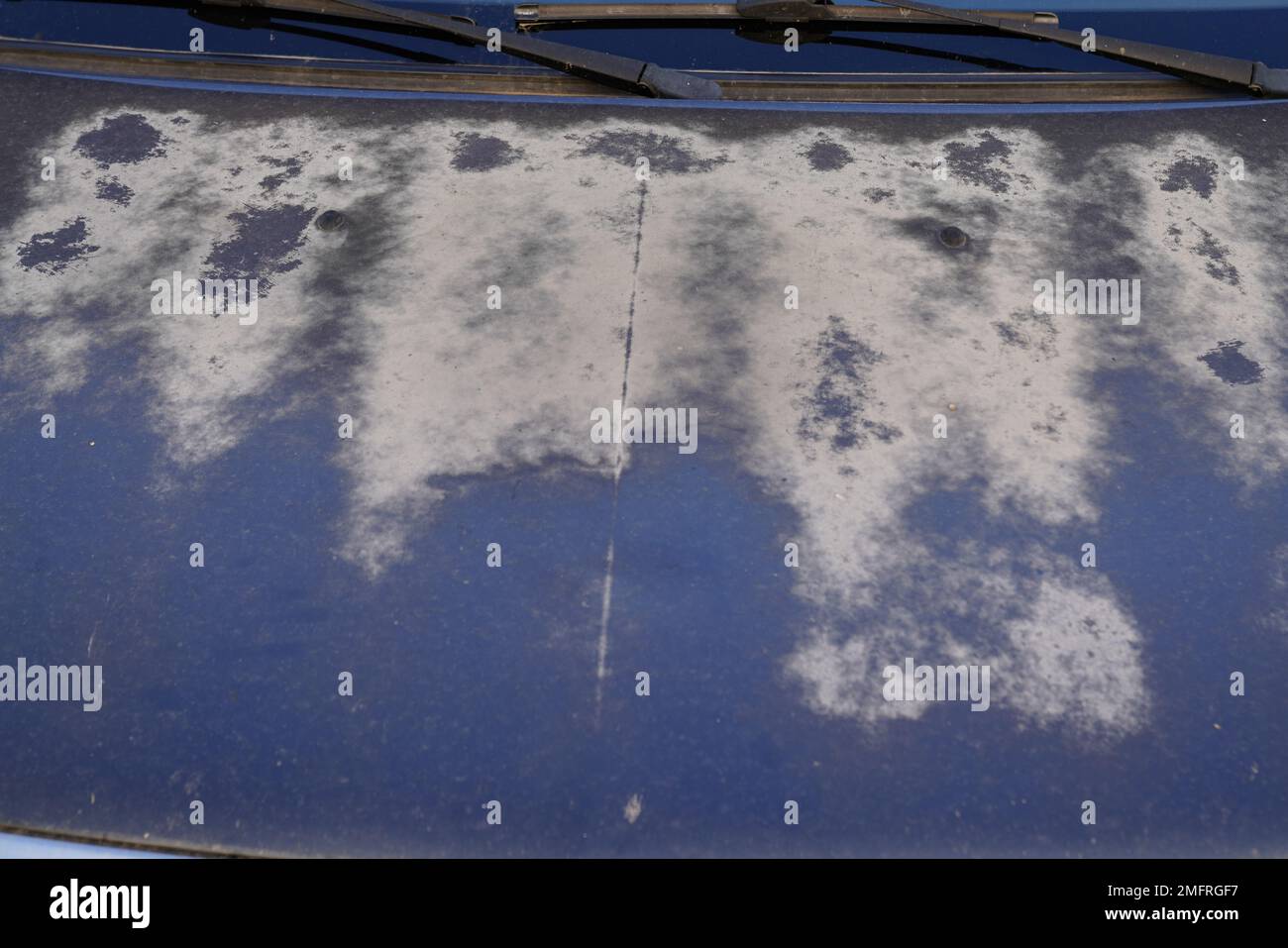 blue car hood with worn worn paint faded by the sun and age Stock Photo