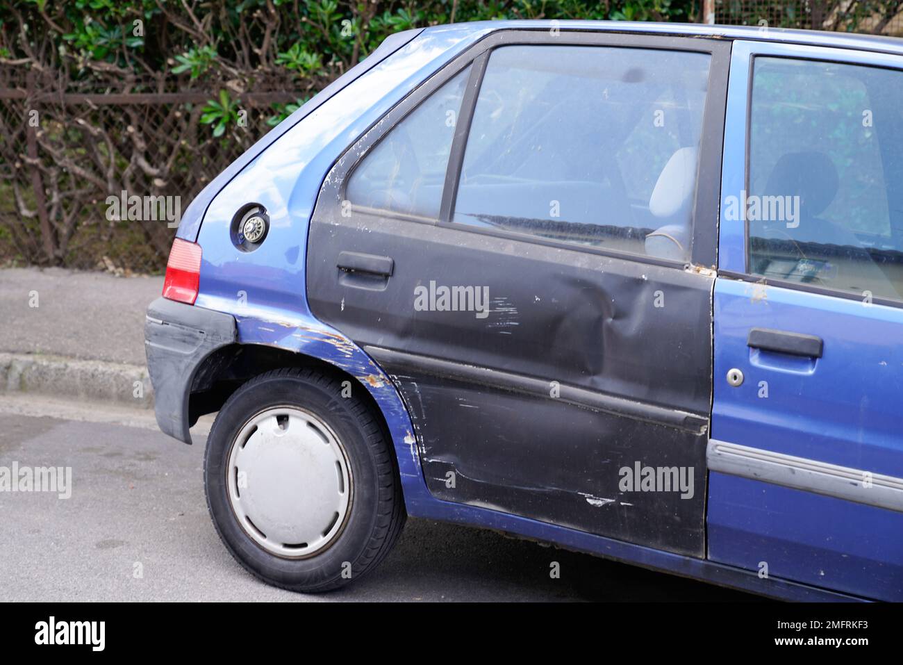 car old bodywork with damage on accident with dent old and used dented striped side rear door Stock Photo