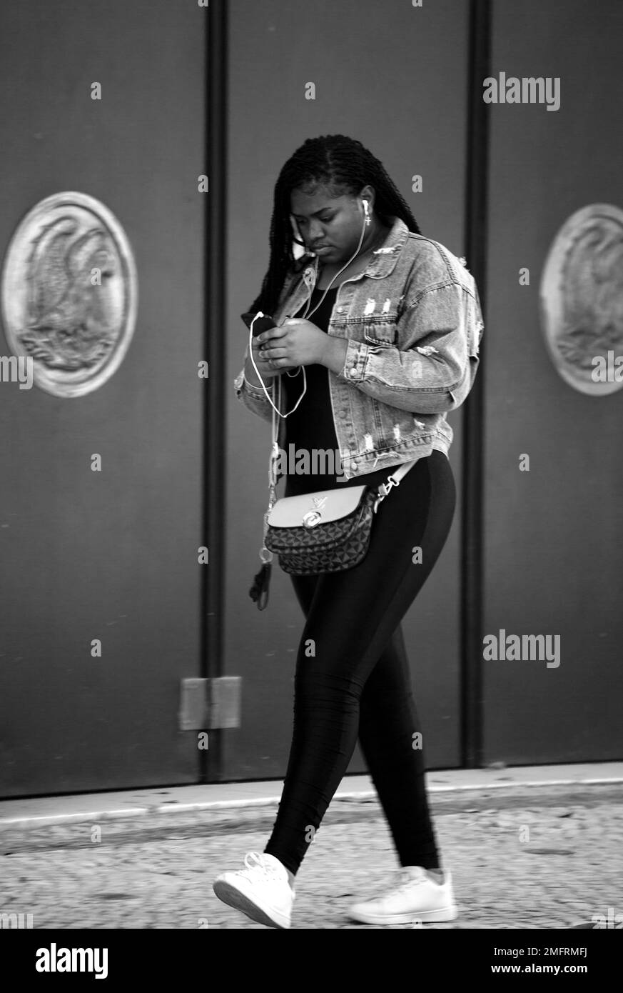 woman with smartphone in hand strolls through the streets of Lisbon Stock Photo