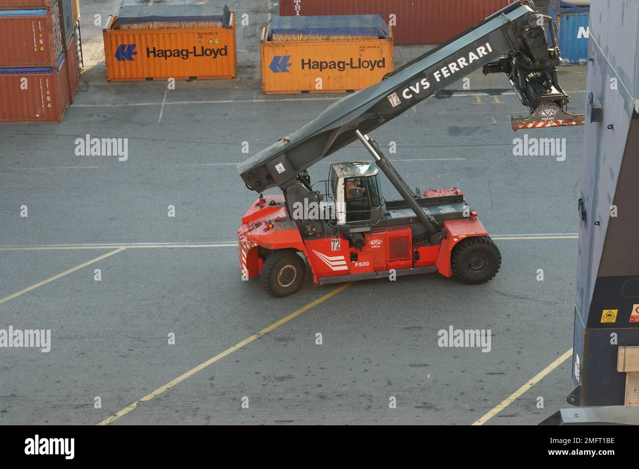 Reach stacker of red colour with top pick  spreader for laden container and intermodal handling in container terminals in port. Stock Photo