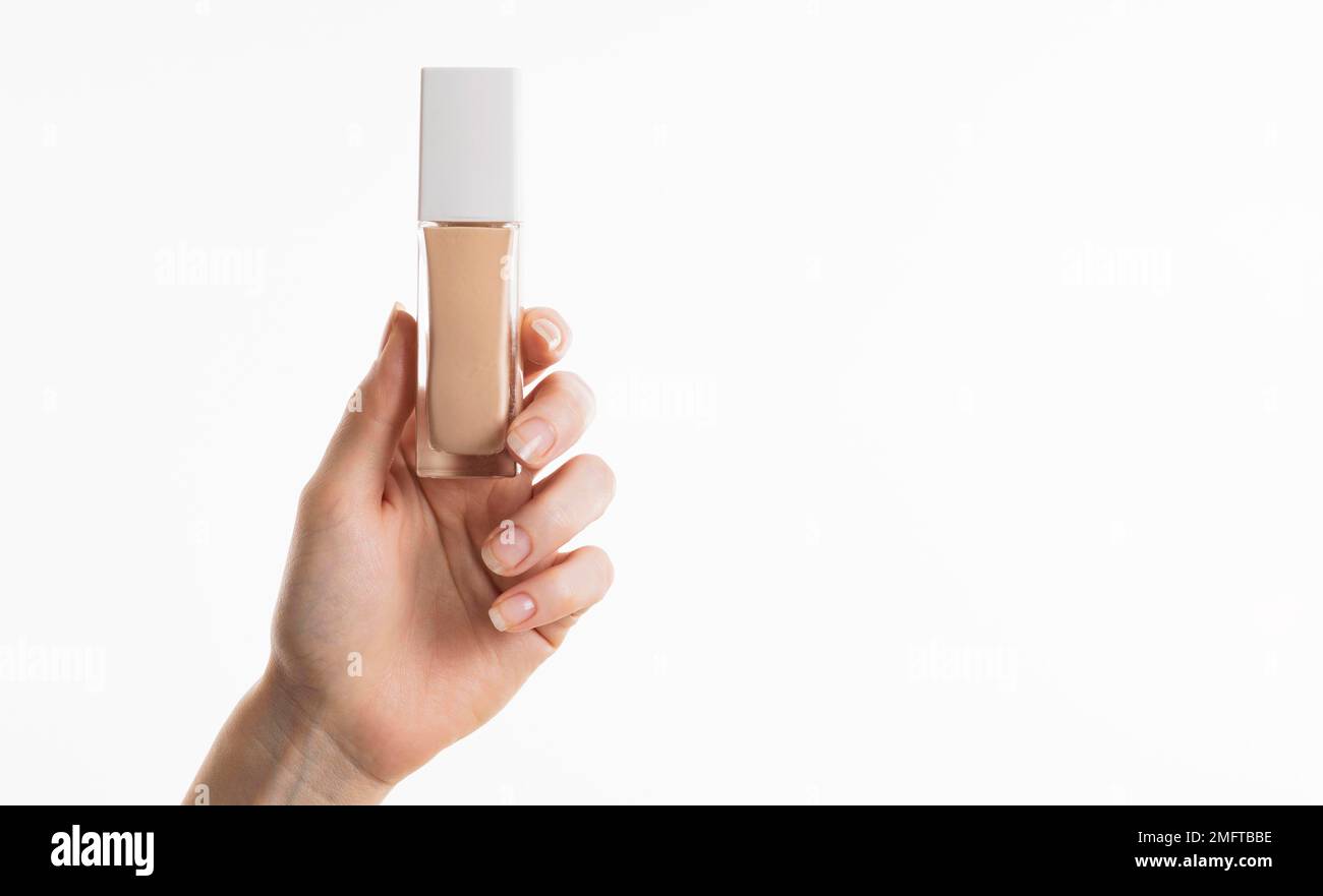 hand holding foundation bottle with copy space Stock Photo Alamy