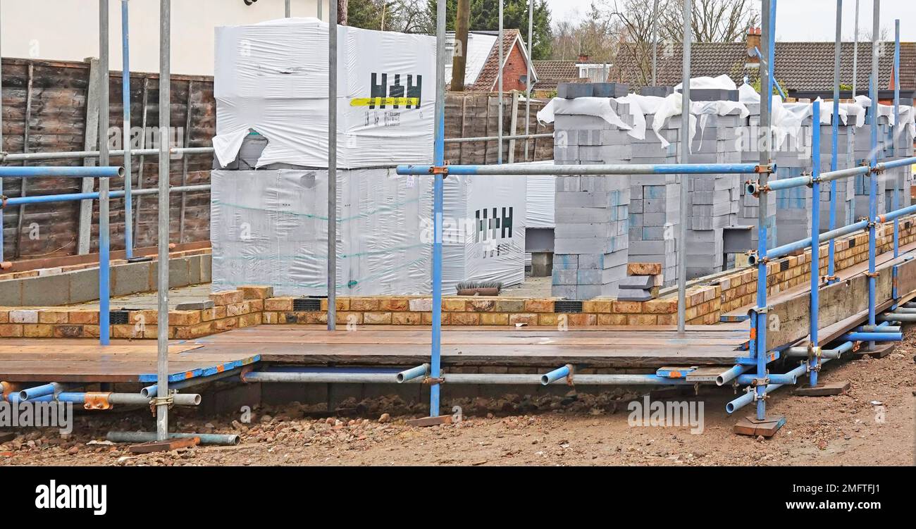 Insulating building blocks by Aircrete H+H Celcon plastic wrapped stacked for bricklayers to build inner skin of cavity wall in new detached house UK Stock Photo