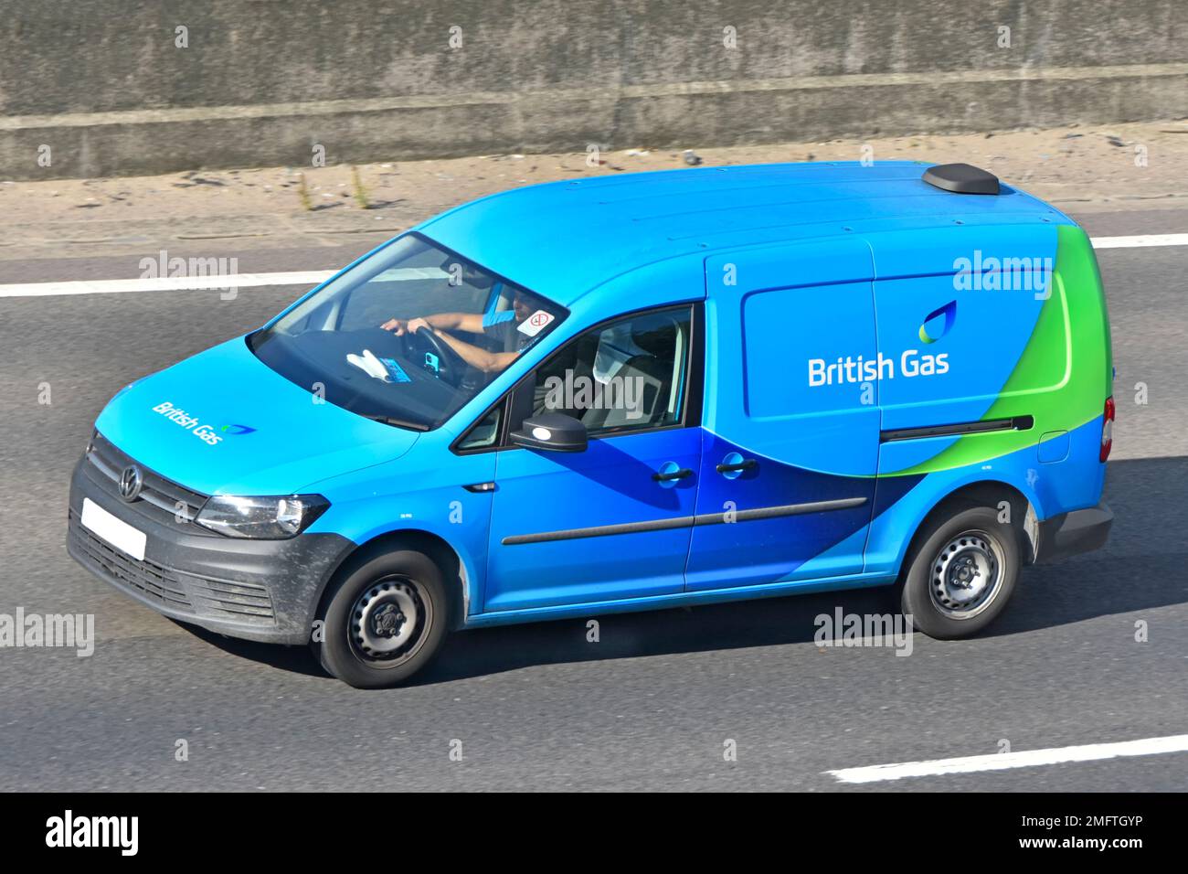 Side roof & front view blue British Gas logo on VW Volkswagen business van a commercial vehicle isolated from traffic employee driving on UK motorway Stock Photo