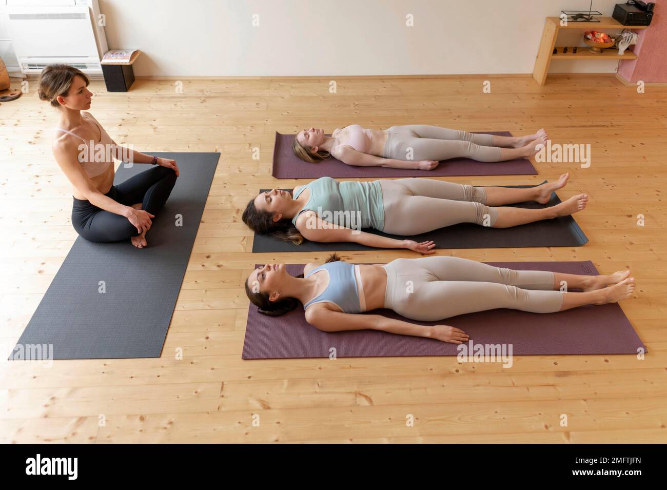 female yoga teacher teaching class 4 Stock Photo