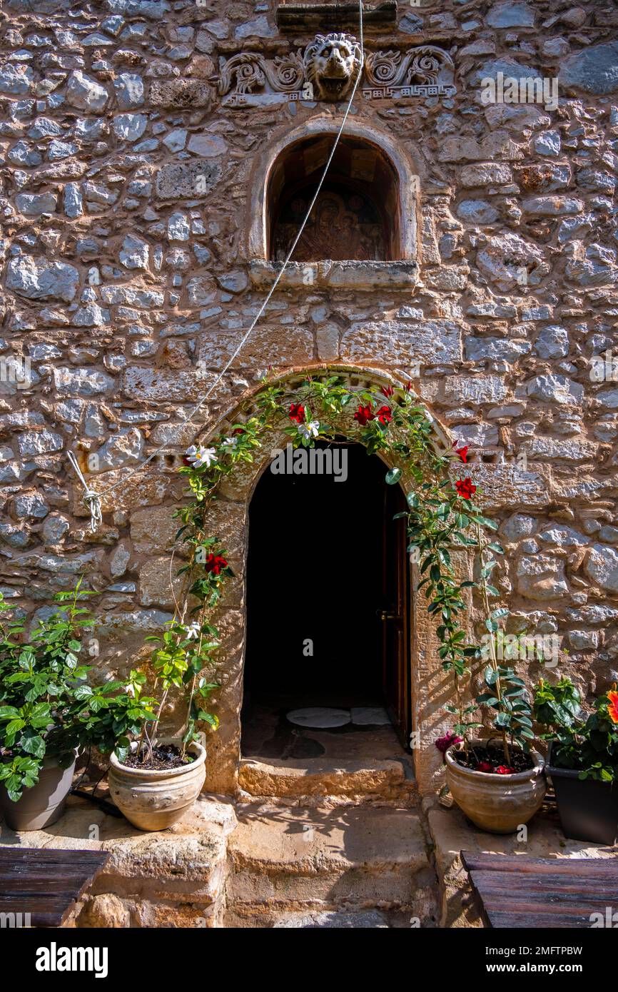 Inner courtyard with flowers, stone building, Moni Agnountos Monastery, Peloponnese, Greece Stock Photo