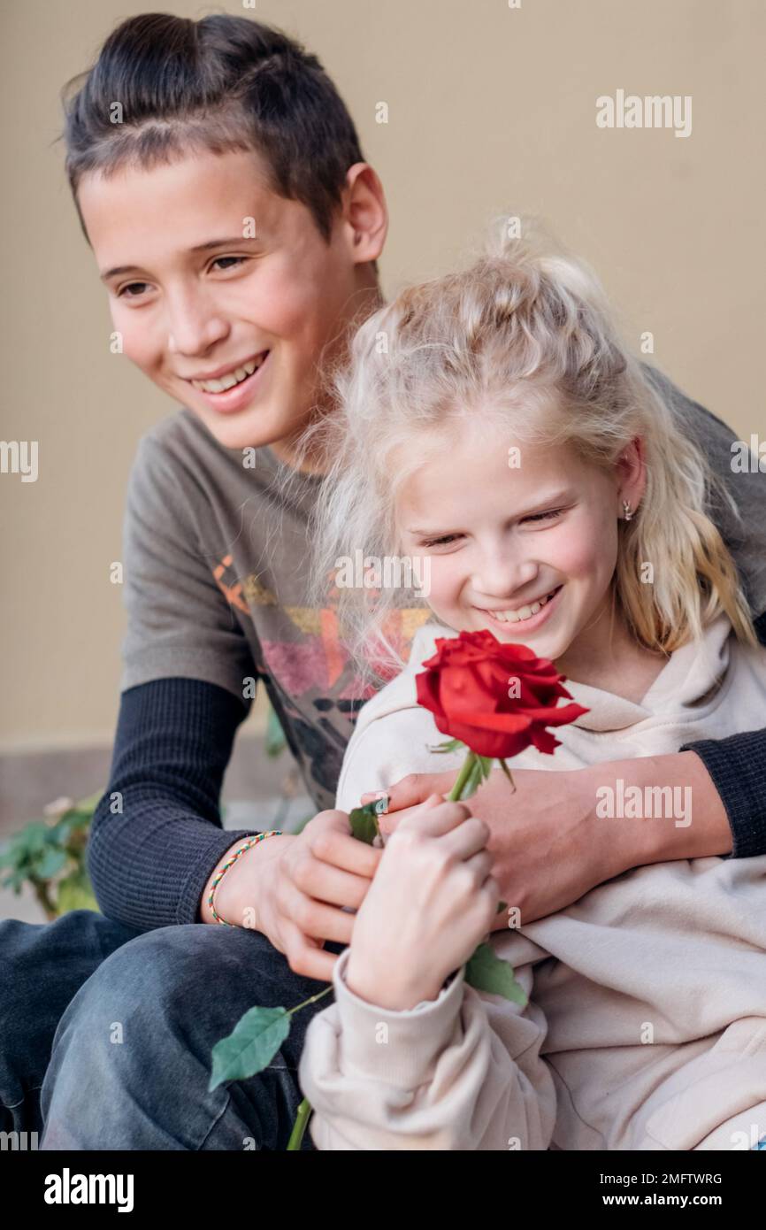 Teen in love on a date. First kids love, teenager boy giving flower to