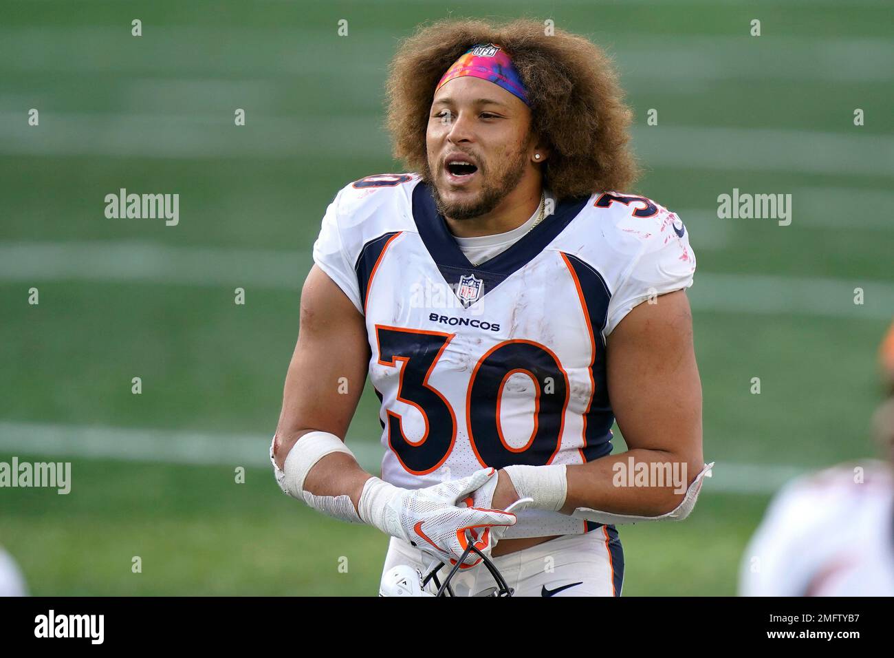 Denver Broncos running back Phillip Lindsay leaves the field after an NFL  football game against the New England Patriots while wearing a headband  with colors supporting Crucial Catch initiative, Sunday, Oct. 18,