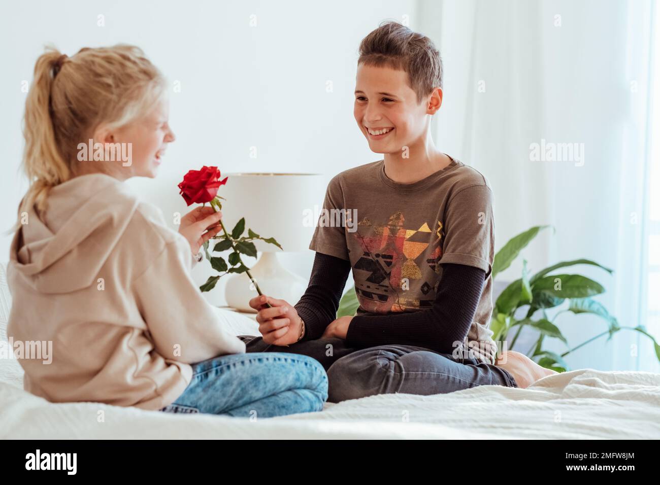 Teen in love on a date. First kids love, teenager boy giving flower to