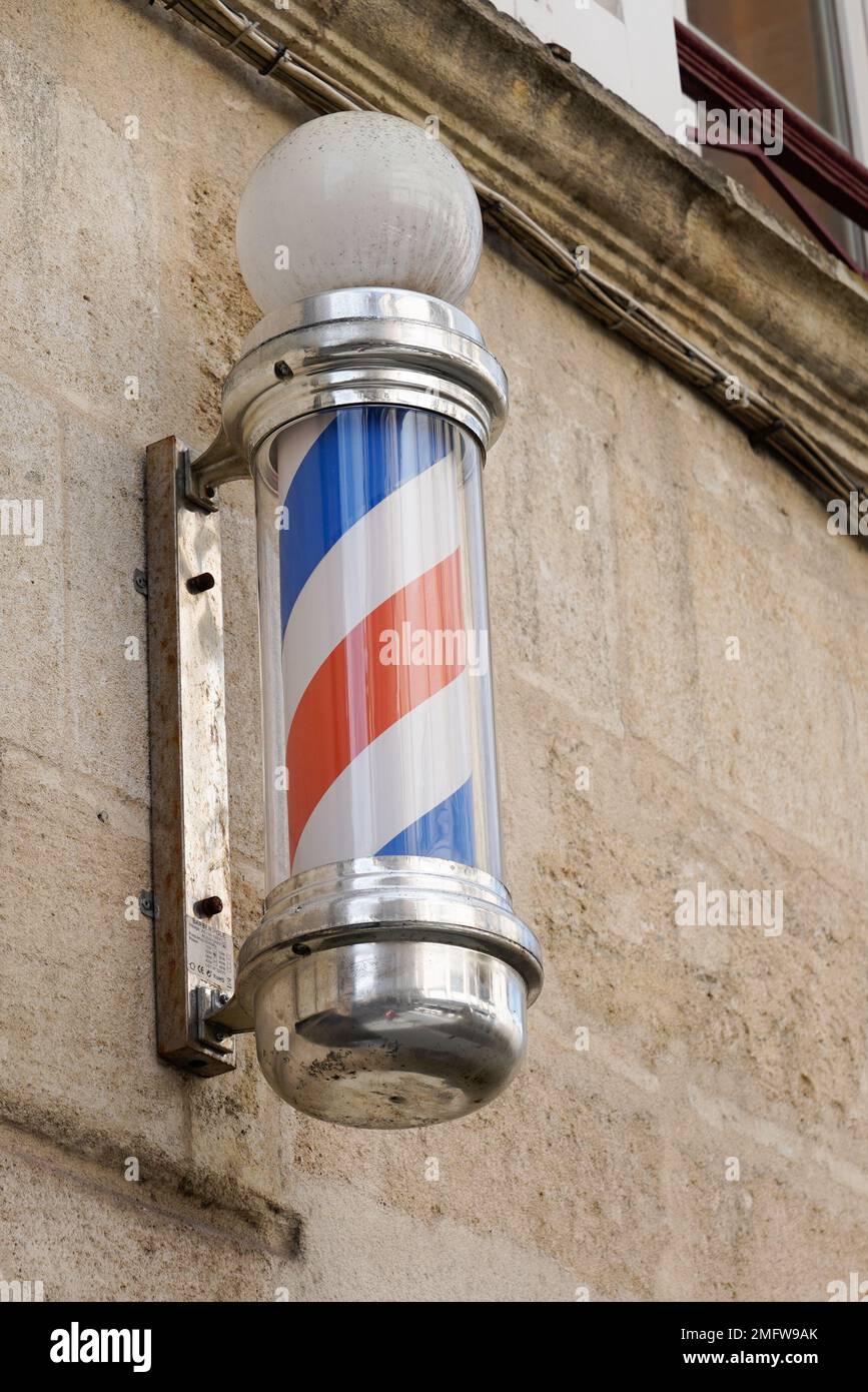 barber colored pole shop sign in vintage hairdresser entrance with round white red blue colors