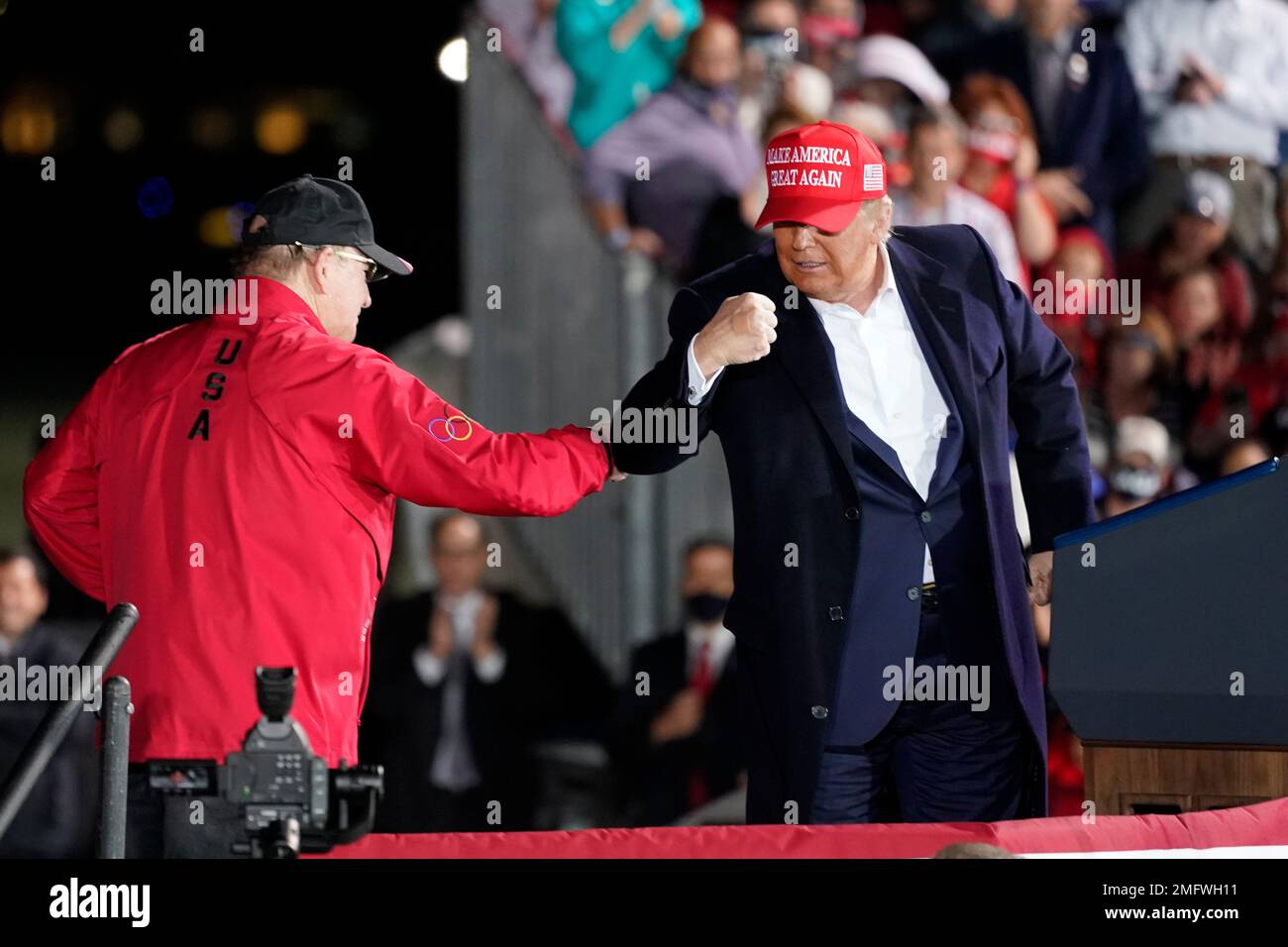 President Donald Trump bumps elbows with Dan Gable during a campaign ...