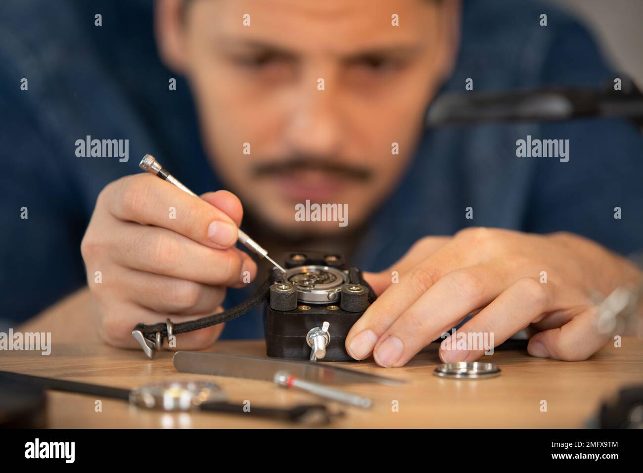 man performing a precision repair on a watch Stock Photo