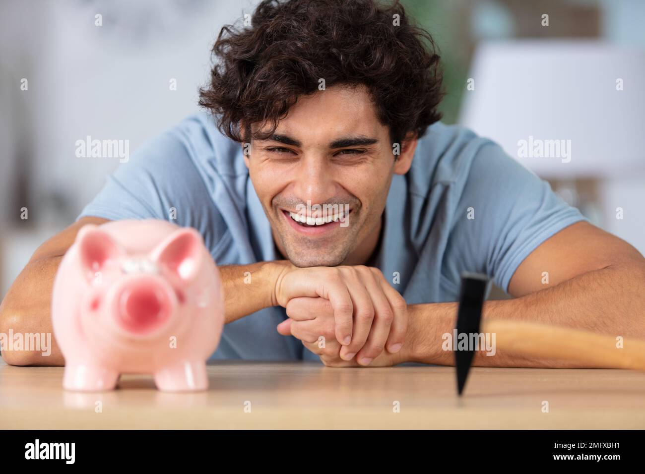 handsome man about to smash a piggy bank Stock Photo - Alamy