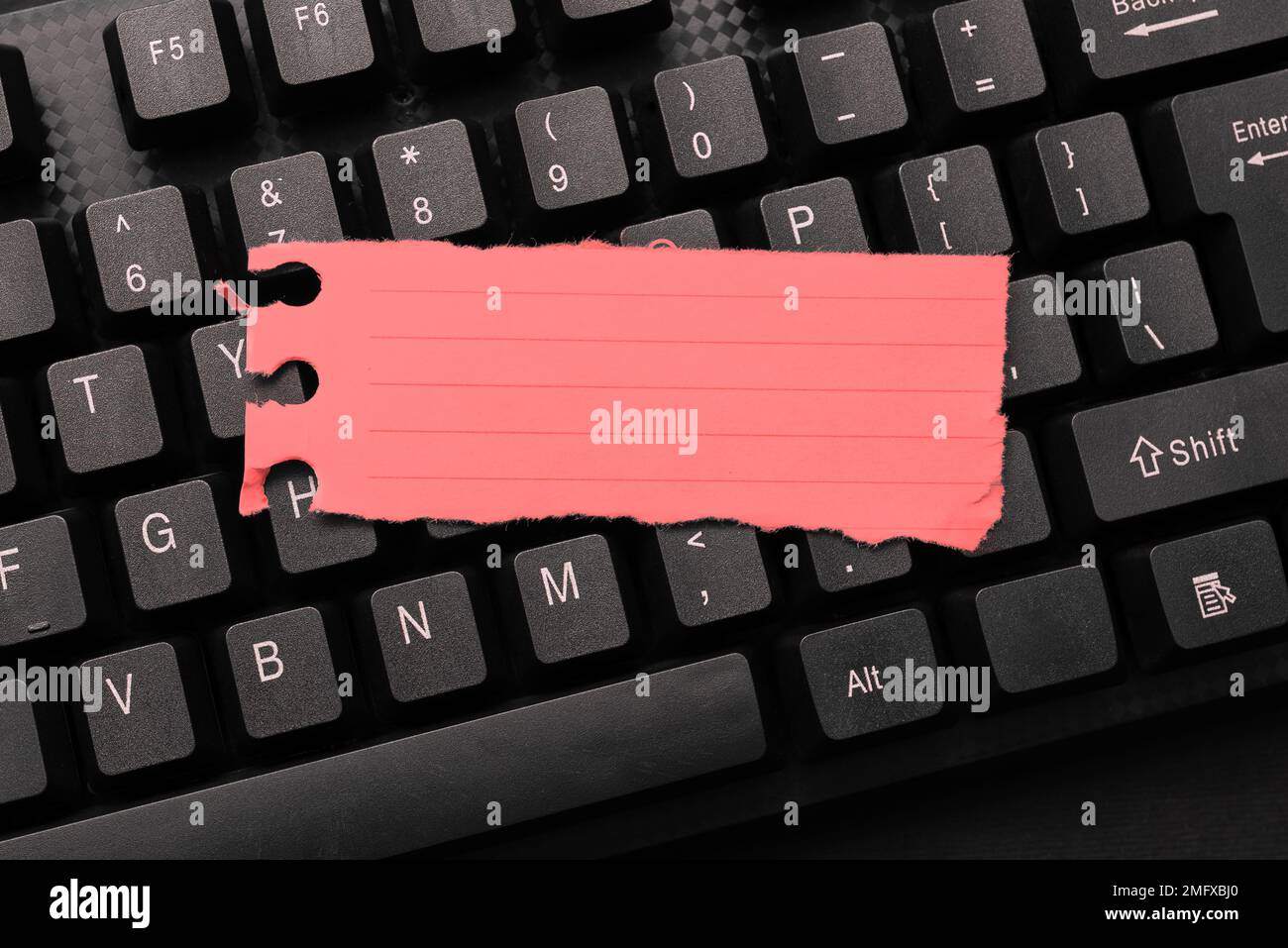 Colored sticker lying on keyboard. Important message written over paper. Stock Photo