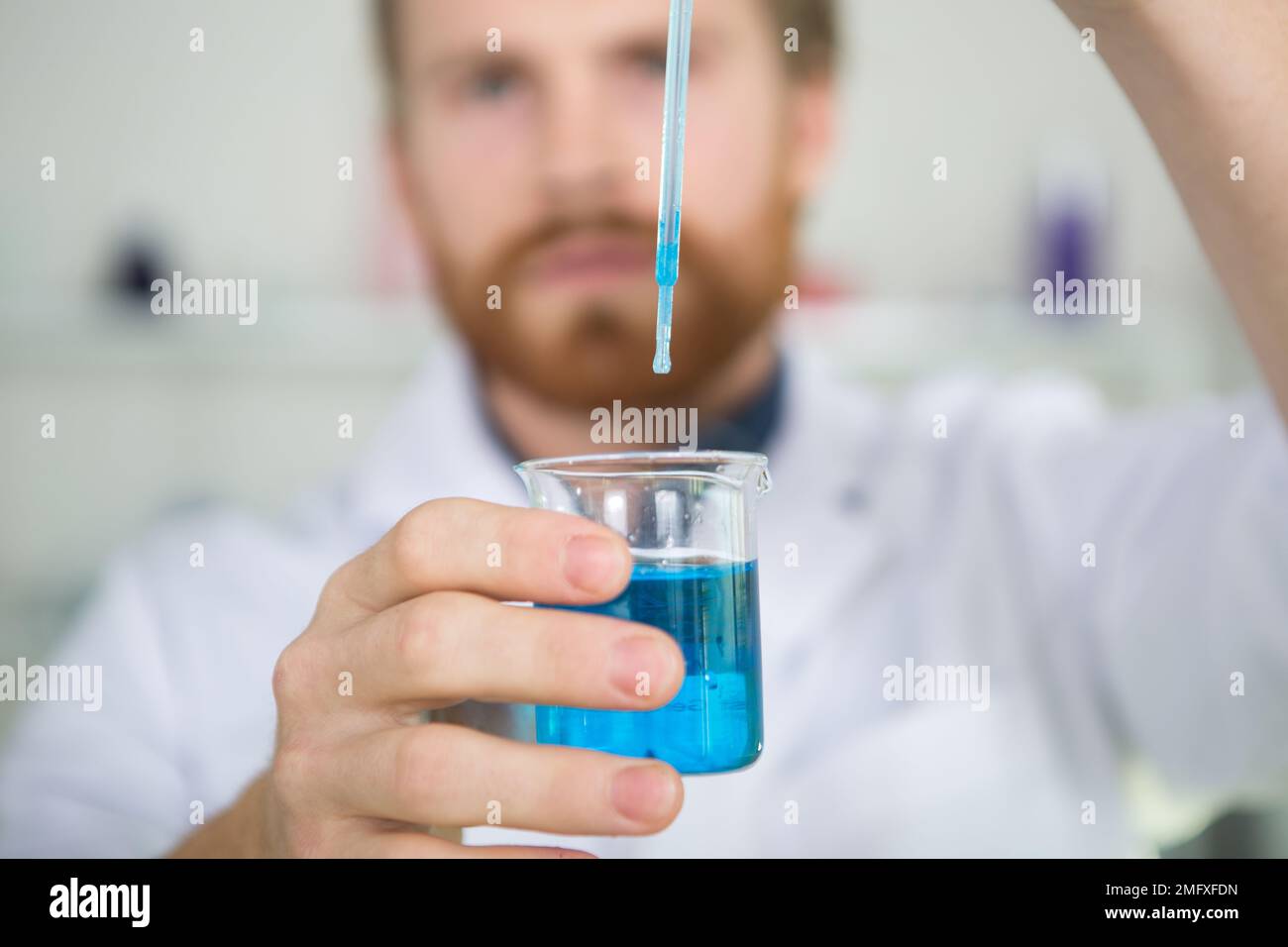 scientist dropping solution from pipette into flask Stock Photo Alamy