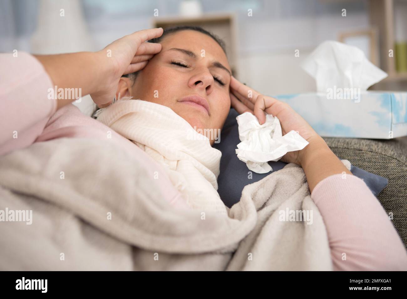 woman layed on the sofa suffering with a migraine Stock Photo - Alamy