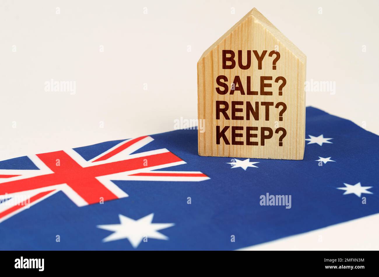 Real estate concept. On the flag of Australia there is a model of a wooden house with the inscription - BUY, SALE, RENT, KEEP Stock Photo