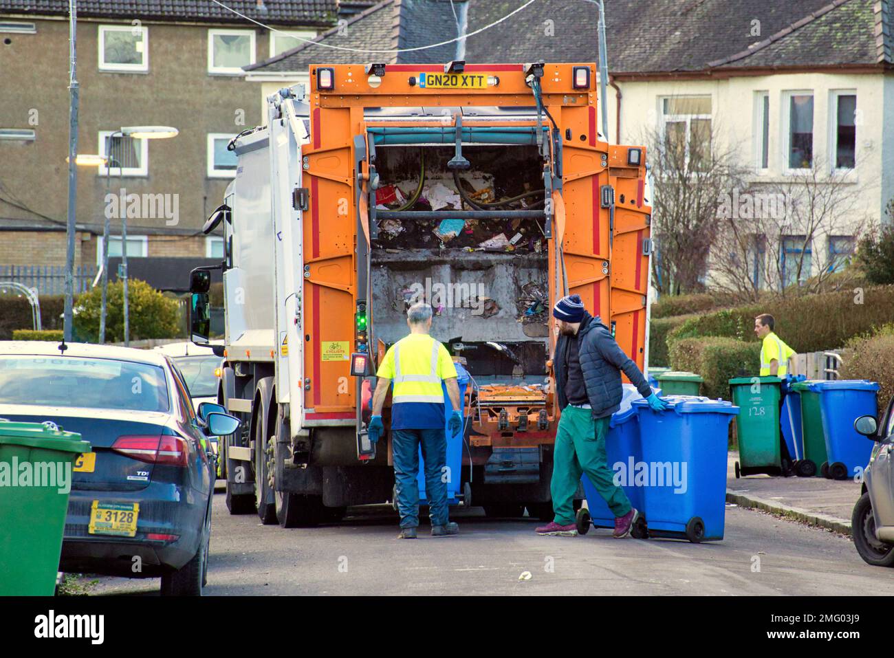 Bin lorry dustmen collecting on suburban street Stock Photo